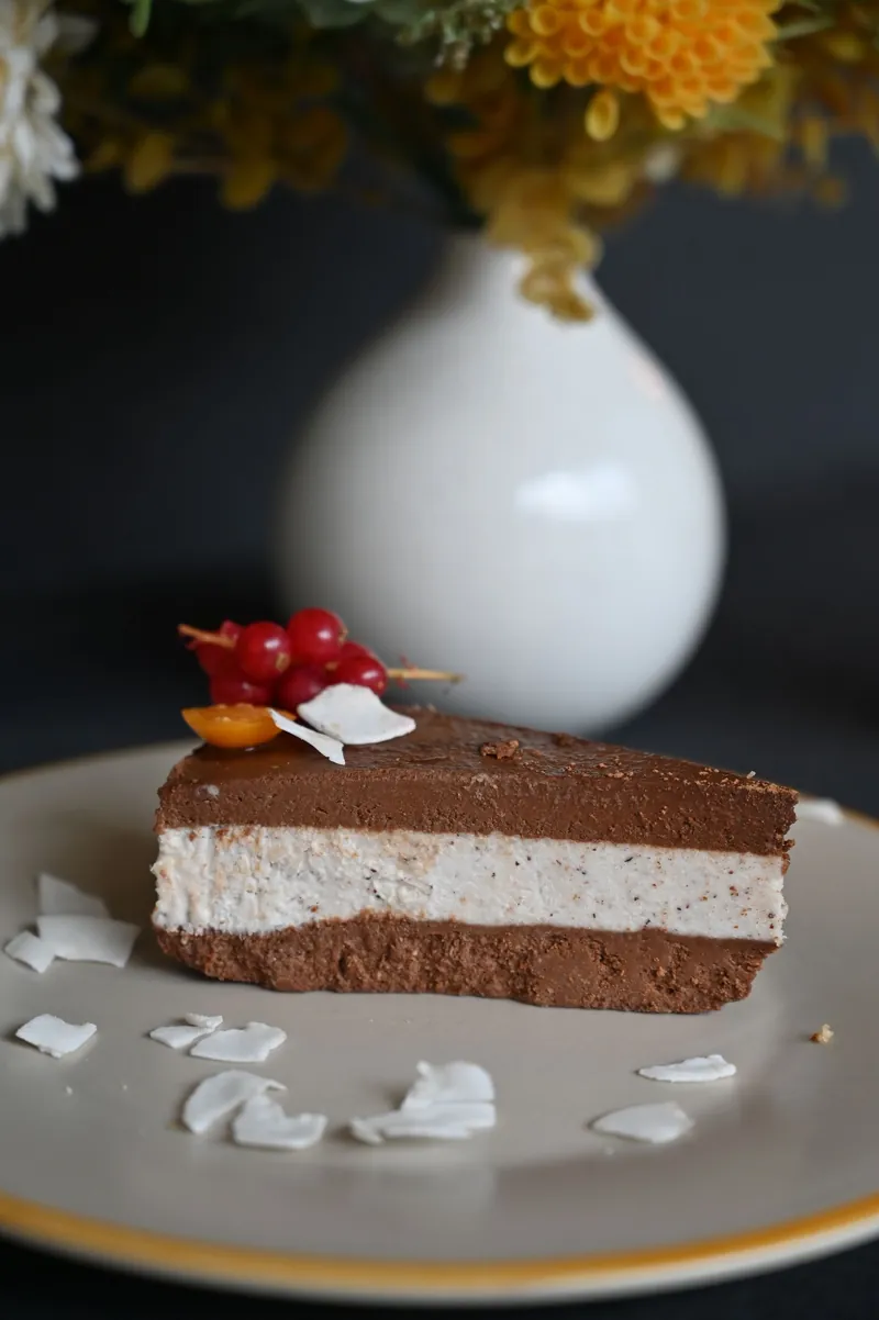 Slice of layered chocolate mousse cake with berries