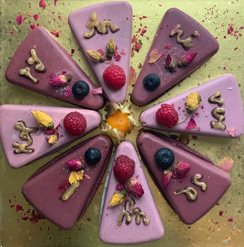 Slices of purple raw cake arranged in a circle with berries and petals