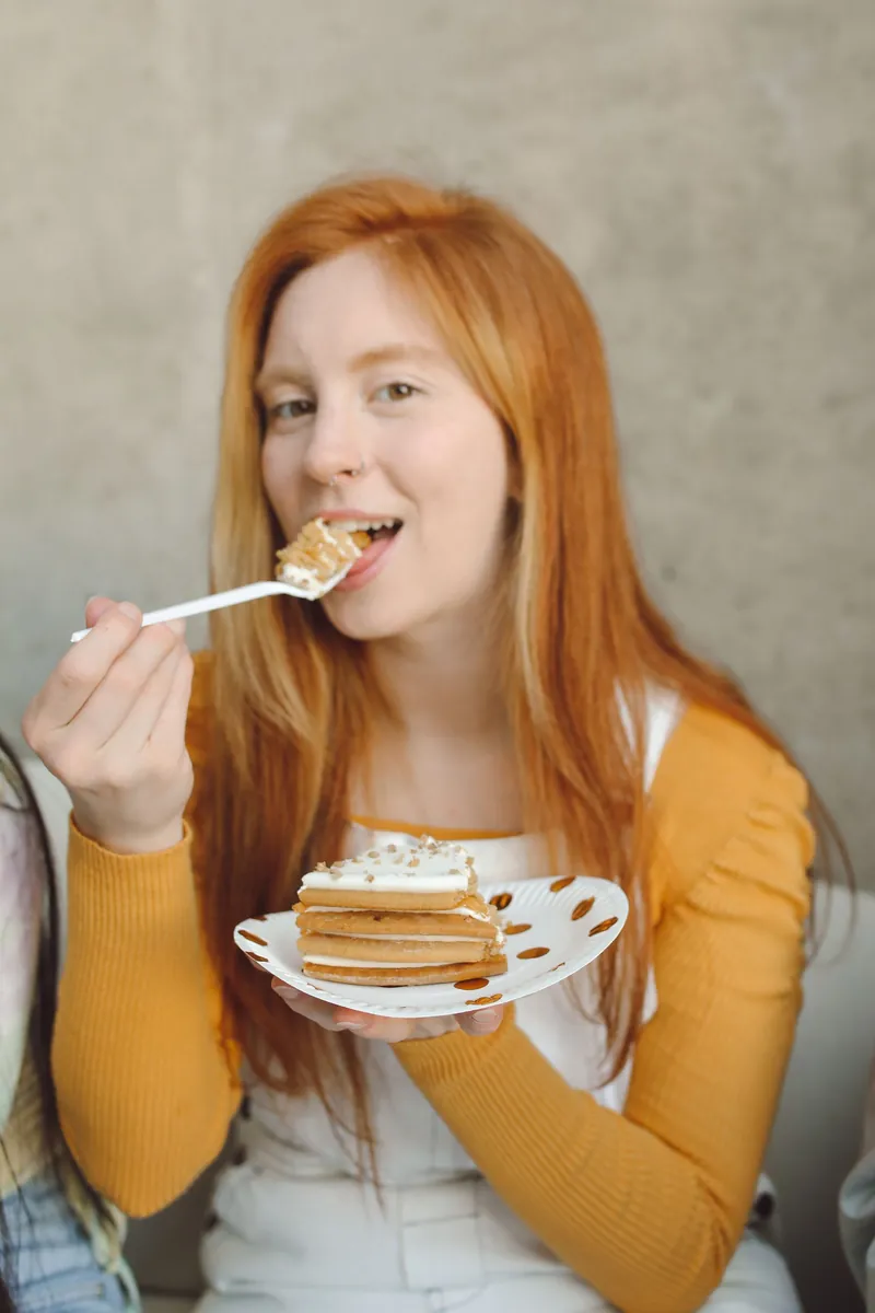 Smiling woman eating a slice of layered cake